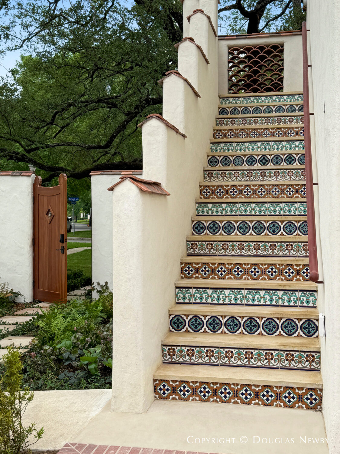 Exterior stairs to staff quarters built in the Spanish Revival and Mediterranean style and decorated with Moroccan tile at 4400 Belfort Place, Highland Park, Dallas, Texas.